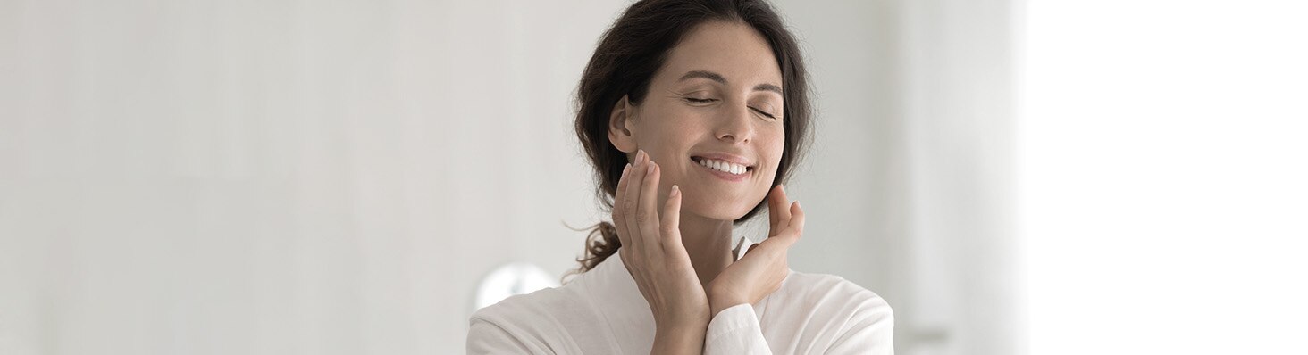 Mujer sonriendo, con piel humectada