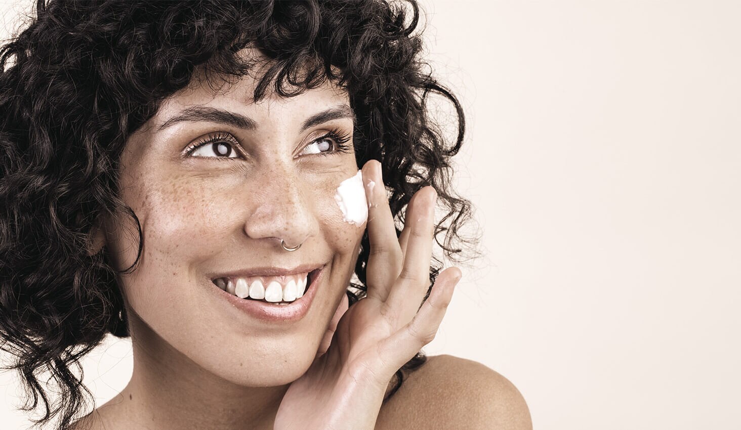 Mujer aplicándose crema en la cara