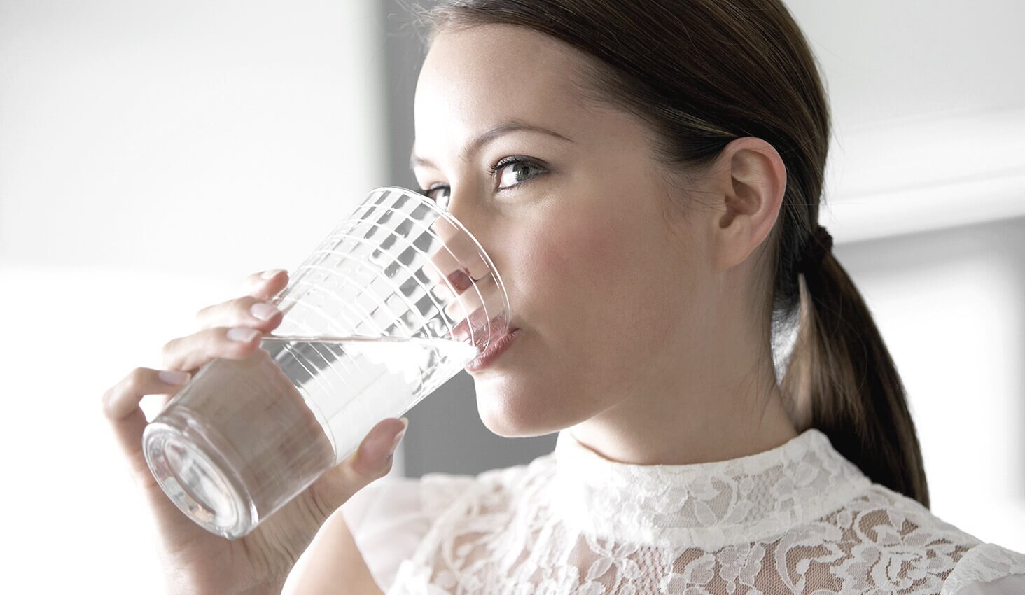 Mujer hidratandose tomando agua
