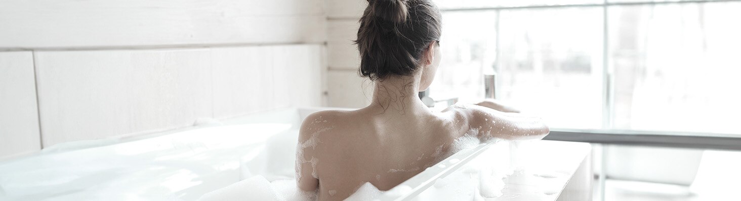 Mujer de espaldas tomando un baño de tina
