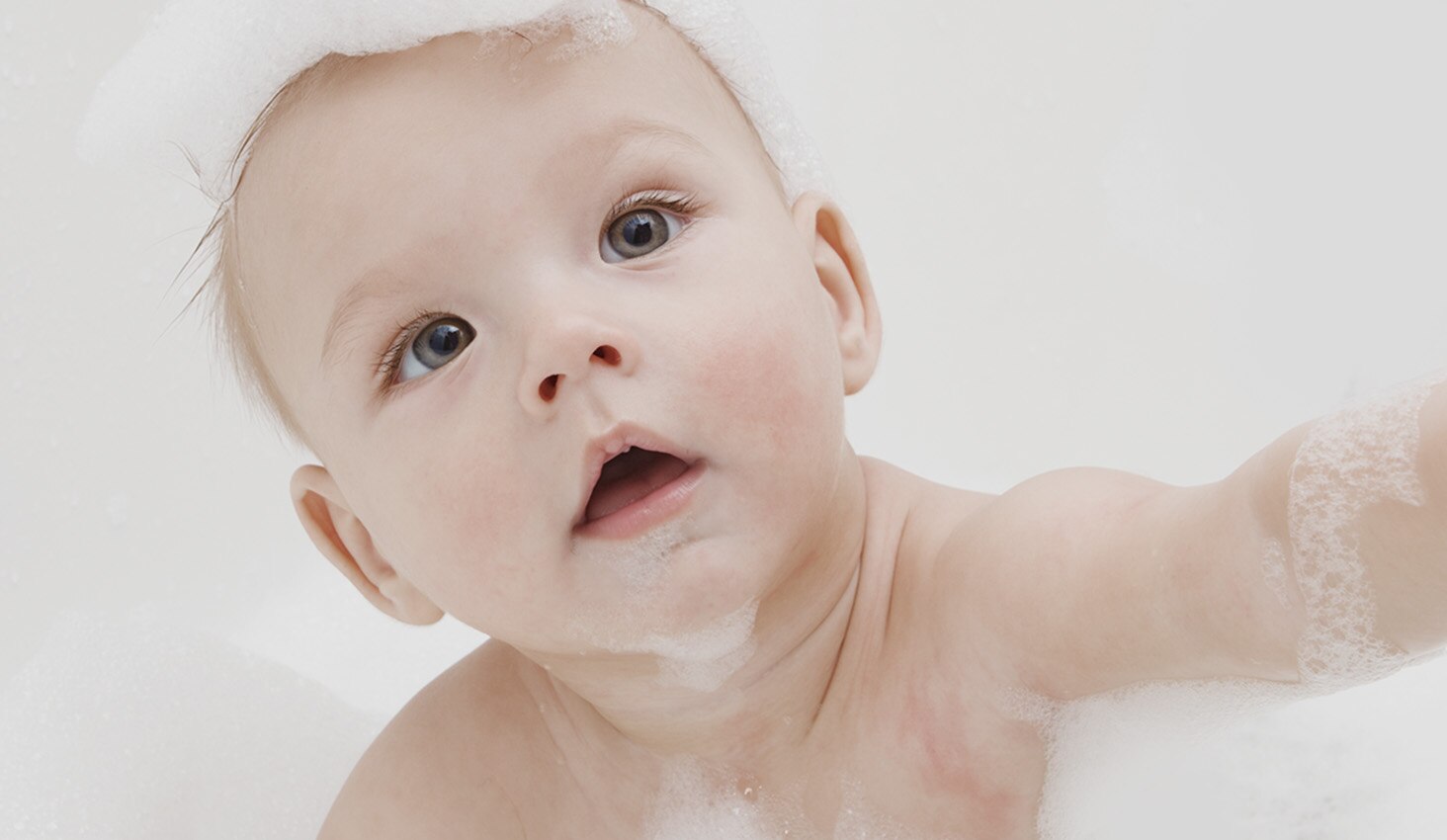 Bebé con espuma de jabón durante el baño