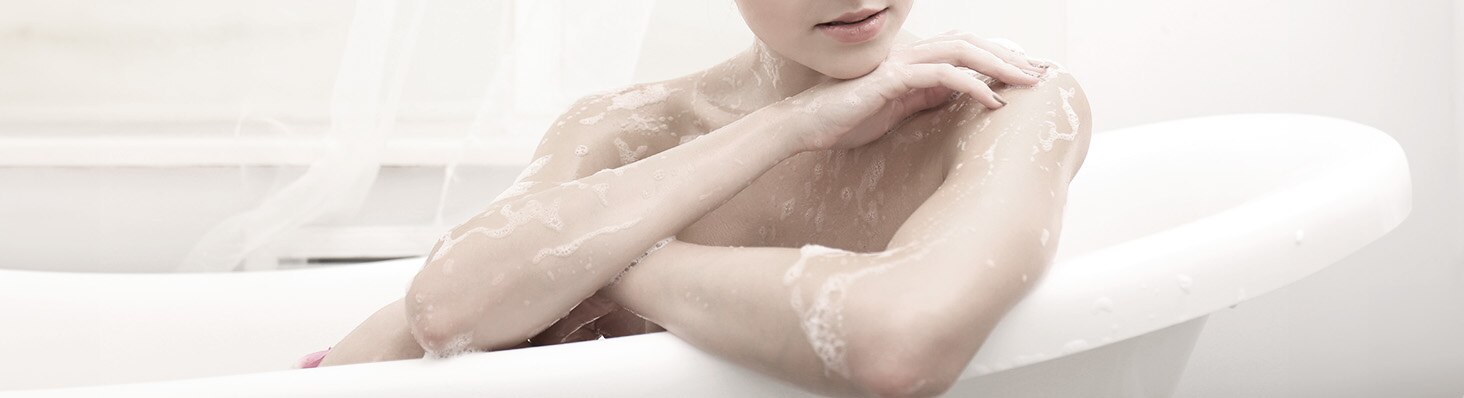 Mujer con piel seca tomando un baño en una tina